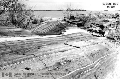 Photo 117969 : Roches sédimentaires grenatifères partiellement métamorphisées du Précambrien; la lame du canif pointe à un gros cristal de grenat, lac Cross (Man.).