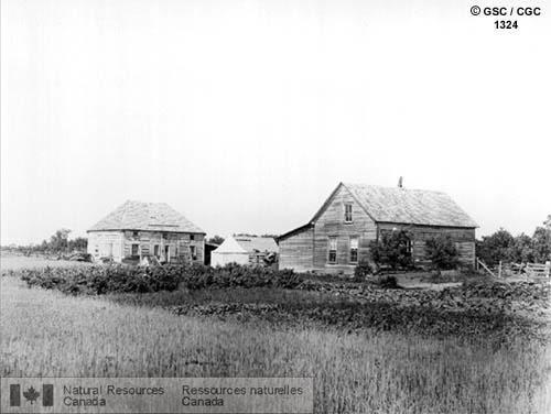 Photo 1324 : L'ancien fort de la Compagnie de la Baie d'Hudson à Portage la Prairie (Manitoba). On voit un groupe de maisons en bois délabrées entourées de  ...