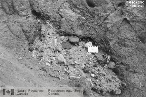 Photo 1999-012E : Lentille de till dans des tufs bréchiques à hyaloclastites, édifice volcanique Ne Ch'e Ddhawa (nom aborigène) à 10 km au sud-ouest de Fort Selkirk,  ...