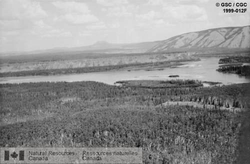 Photo 1999-012F : Coulées basaltiques remplissant la vallée préglaciaire de la rivière Yukon au confluent des rivières Yukon et Pelly. Les palissades formées par les  ...