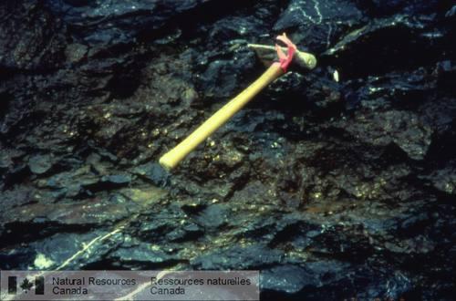 Photo 1999-016N : Minerai de remplacement stratoïde de sulfures massifs dans du calcaire; rivière Ketza, Yukon