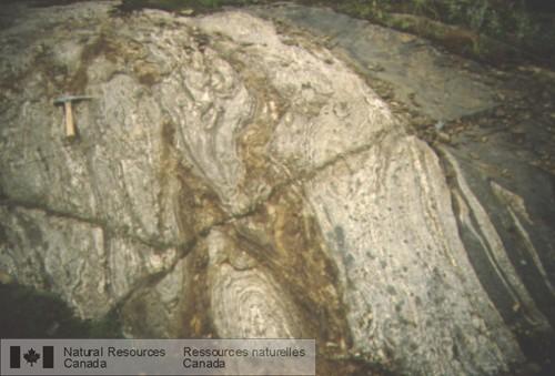 Photo 2003-024 : Quartzite gris intercalé avec du paragneiss quartzofeldspathique rouillé et des niveaux décimétriques d'amphibolite, à grain fin, transposés(?),  ...