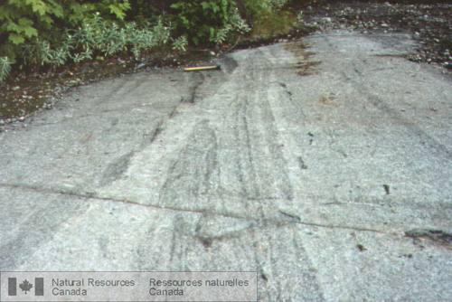 Photo 2003-087 : Chenal d'érosion magmatique à la verticale et contact intrusif discordant recoupant un litage modal discontinu dans l'Intrusion litée de Lacordaire.  ...