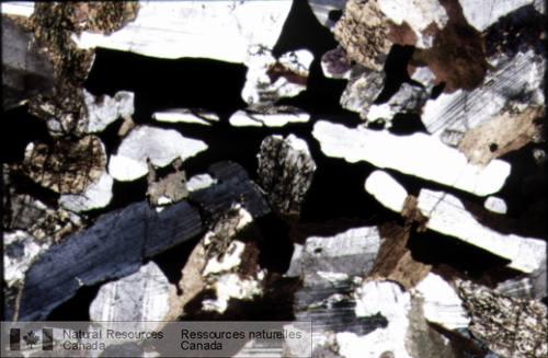 Photo 2003-116 : Photomicrographie d'un gabbronorite. Le pyroxène est en grains grenus tandis que la magnétite occupe les interstices laissés par le plagioclase en  ...
