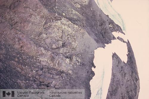 Photo 2003-316 : Discordance angulaire séparant des coulées de lave fortement inclinées du Groupe de Stuhini de strates argileuses légèrement inclinées du Groupe de  ...