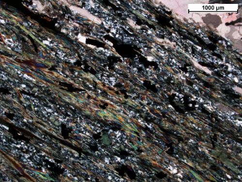 Photo 2013-302: Disseminated chalcopyrite and pyrite grains within a chlorite-actinolite-quartz-rich rock, 104 m above mineralization (cross-polarized; sample 62167;  ...