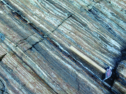 Photo 2018-343: Silicate-facies banded iron formation at Tuktuliarvik, consisting of alternating layers of quartz, magnetite and cummingtonite-grunerite±garnet  ...