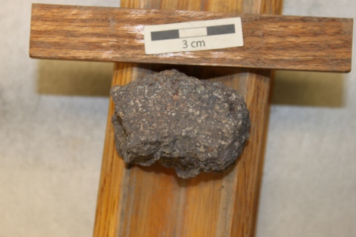 Photo 2019-304: Weathered amygdaloidal basalt with white to pink zeolite mineral infills. Black scale bars are 1 cm in length.
