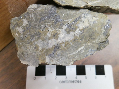 Photo 2020-115 : Sample of mineralization from the Hawk Creek deposit: hand sample of massive aggregate of very fine grained, honey-yellow sphalerite (Sph 1) and  ...
