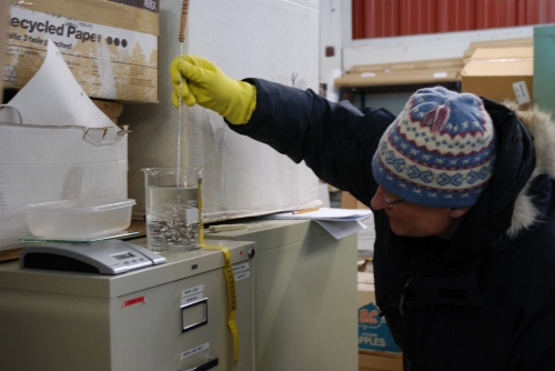 Photo 2020-392 : Scientist in the process of determining the weight and volume of an ice core section for the purpose of estimating its density.
