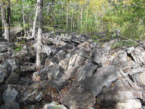 Photo 2020-615: Typical view of the slag disposal area. The slag occurs in large chunks of varying size, texture, and degree of weathering