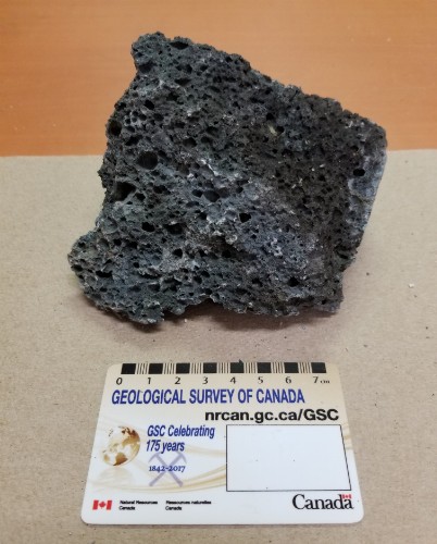 Photo 2020-632: Sample of sponge-like slag. This material is a dark grey-green and shows little visible sign of weathering