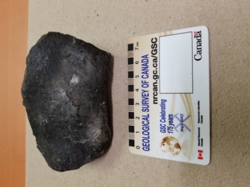 Photo 2020-633: Sample of glassy slag. This material is a glossy black and shows little visible sign of weathering