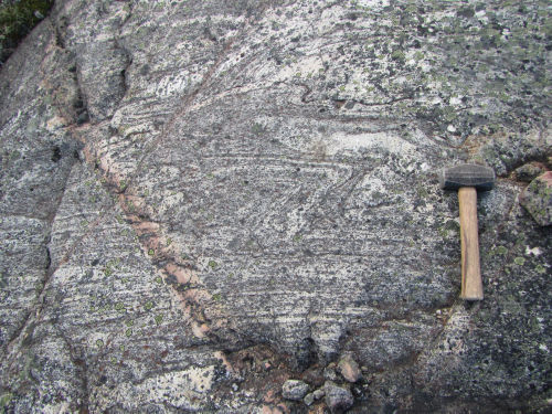 Photo 2022-281: 12628/18CXAD0048A - granite gneiss W of Ingrid Lake.  Hammer for scale is 30cm long