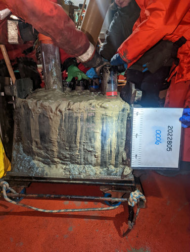 Photo 2023-052 : Box core collected from Nachvak Fjord, Labrador showing placement of push core (orange cap) collected by GSC-A.