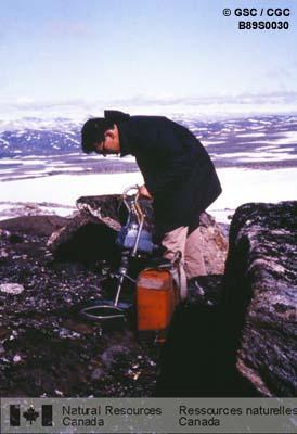 Photo B89S0030 : Prélèvement d'une carotte échantillon orientée sur un dyke de diabase dans la partie centrale nord de l'île de Baffin.