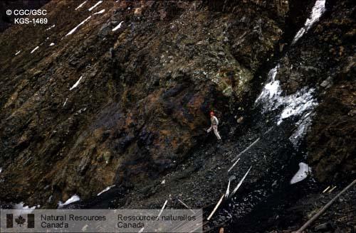 Photo KGS-1469 : Affleurement du gisement de la Compagnie minière et métallurgique de la baie d'Hudson au ruisseau Quill, route de l'Alaska, avec Jim Aiken sur la  ...